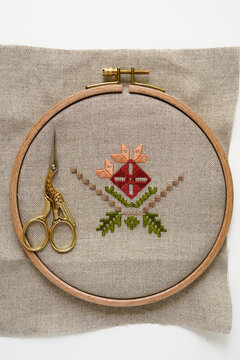 Natural linen fabric in a wooden embroidery hoop, featuring hand embroidery. Traditional Ukrainian embroidery, an example of a colorful pattern.