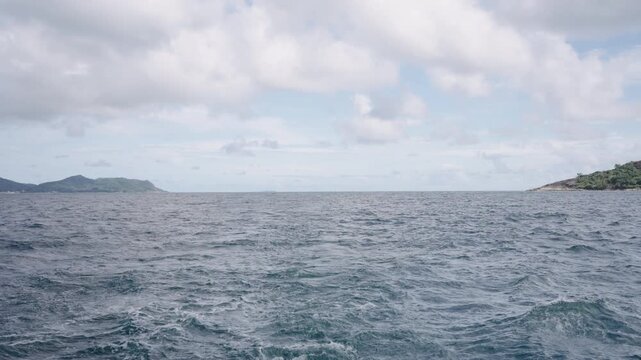 Slow motion side view from boat in Indian ocean sailing between Seychelles islands in daytime