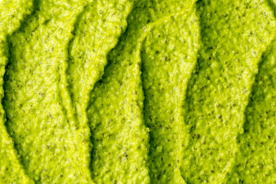 Green yogurt ice cream with pistachios, kiwi and avocado. Fresh fruit smoothie. Ice cream texture. Delicious sweet dessert close-up as background.