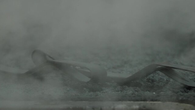 Metal Tongs Shrouded in Thick Steam and Vapor