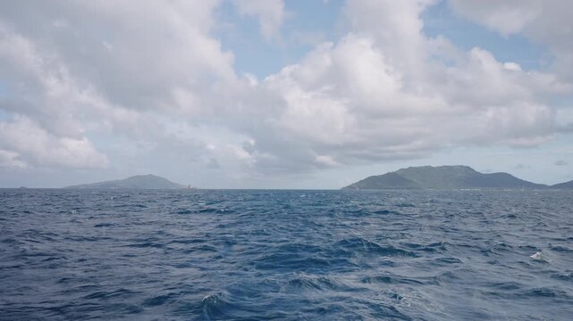Slow motion side view from boat in Indian ocean sailing between Seychelles islands in daytime