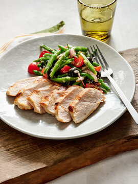 Grilled chicken breast with green beans and cherry tomatoes, healthy meal prep, family dinner concept