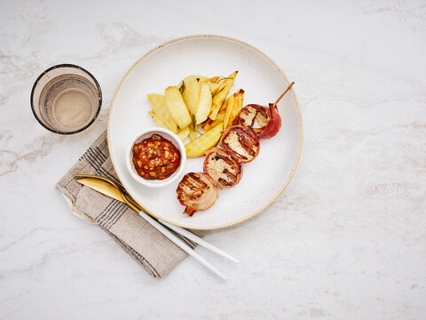 Grilled chicken skewers with fries and dipping sauce, perfect for casual dining and family meals