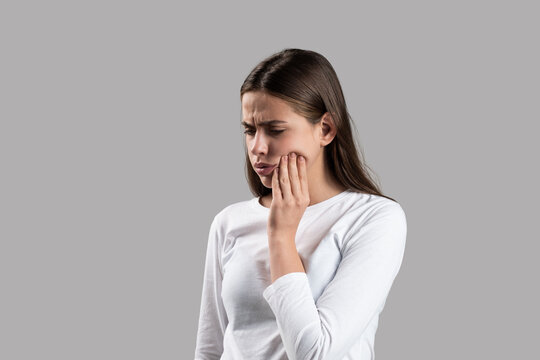 Toothache as dental pain. Teeth problem. Woman feeling tooth pain. Dental health and care concept. Girl suffer from toothache gray background. Toothache painkiller. Dental disease