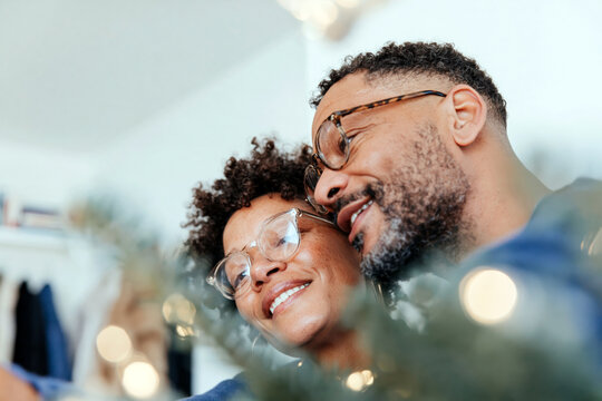 Affectionate Couple Smiling Together by Christmas Tree at Home