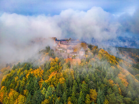 FRANCE, ALSACE, BAS-RHIN 67, OTTROTT, AERIAL VIEW OF MONT SAINTE-ODILE ABBEY IN MIST, OVERLOOKING THE BRUCHE VALLEY AND ALSACE PLAIN, AMID GOLDEN AUTUMN VOSGES FORESTS.