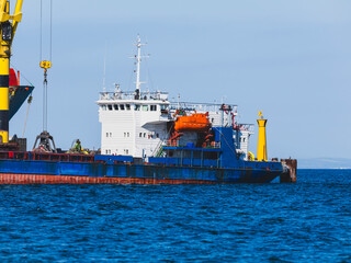 Fototapeta premium Commercial cargo ship unloading at a port