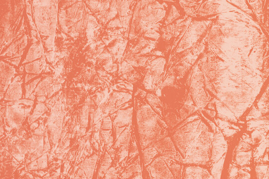 Coral pink textured background showing a crumpled, creased surface reminiscent of crushed paper or cracked foil. Modern and edgy graphic backdrop.