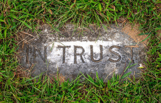 High angle view of ancient in ground gravestone that reads IN TRUST