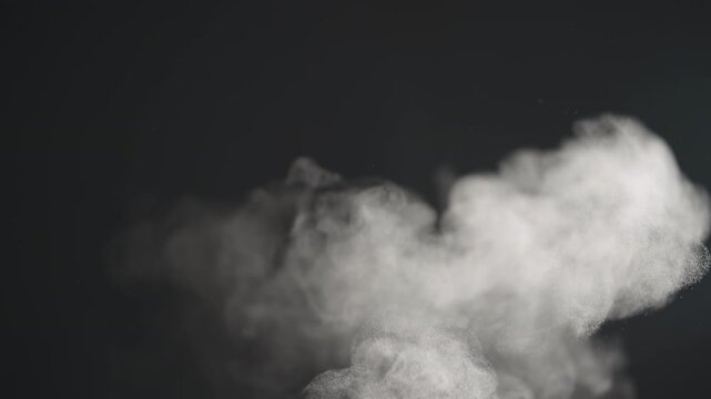 Slow motion steam rising from boiling water over black background