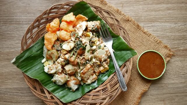 Gado - gado Indonesian traditional vegan food with peanut sauce and crackers served on table top