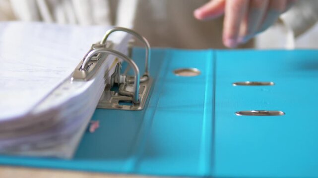 Hand Opening Blue Ring Binder and Extracting Document Folders, Archiving and Record Retrieval Concept
