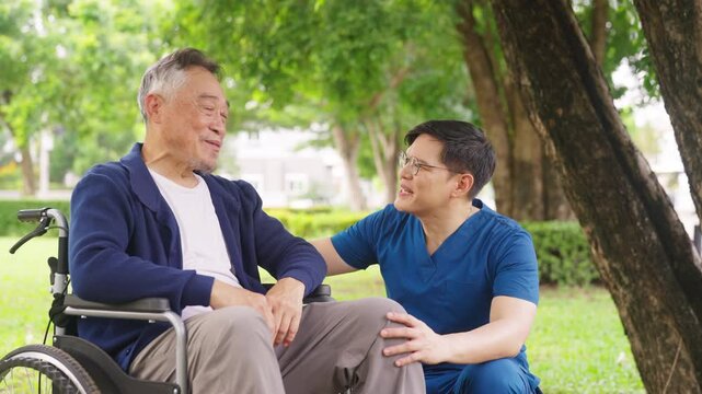 Asian male caregiver pushing senior man in wheelchair for outdoor walk near home, talking and spending time together, elderly mental health care, companionship, mobility support and home healthcare