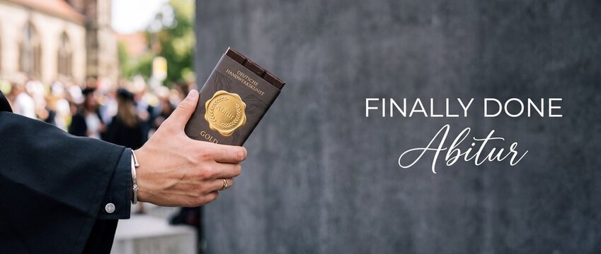 Abitur graduation gift chocolate bar held by graduate student celebrating high school diploma success, German final exam passed celebration concept with finally done text overlay and banner space