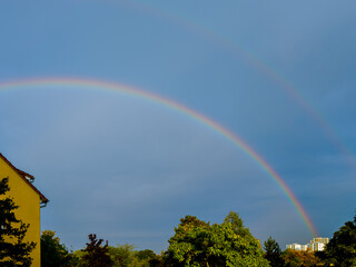 Obraz premium Double rainbow in the dark blue sky over the city