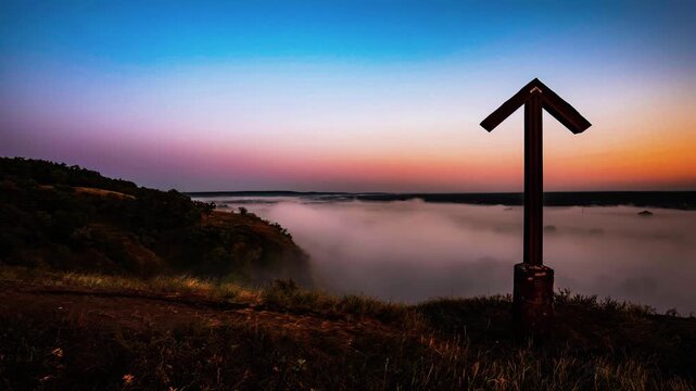 Low fog blankets a remote wilderness landscape beneath a colorful morning horizon.