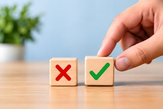 A hand placing a wooden block with a green check mark next to a red cross, representing decision making, choosing the right option, and positive feedback concept.