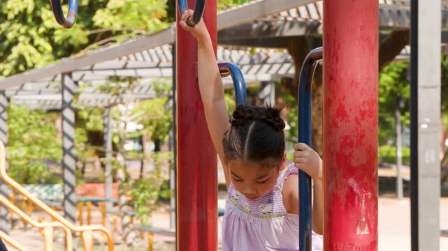 Young Girl Playing on Monkey Bars at Lumpini Park Bangkok