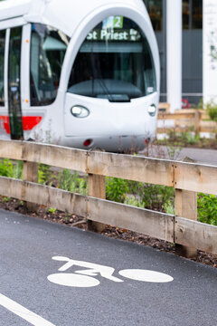 Modern tram beside a marked bicycle lane, combining cycling, public transit and transport infrastructure on a contemporary urban street