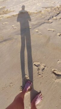La silhouette d'une ombre qui marche sur la plage et dans les vagues