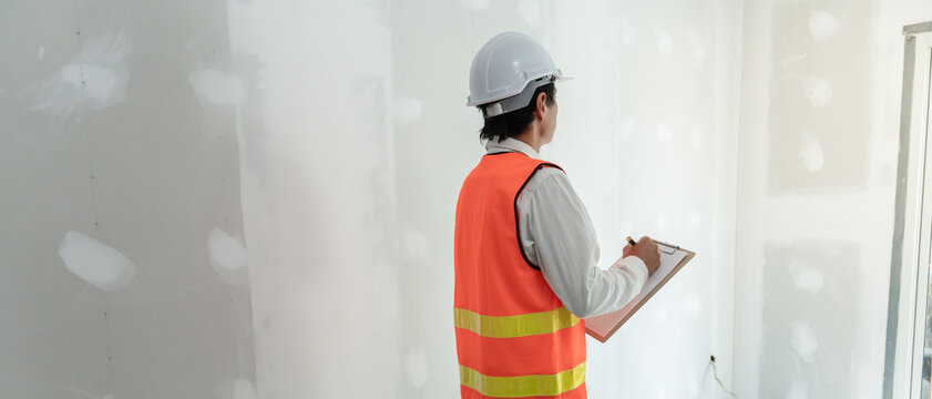 inspector or engineer is inspecting construction and quality assurance new house using a checklist. Engineers or architects or contactor work to build the house before handing it over to the homeowner