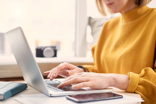 Woman working on laptop, typing on keyboard, close up