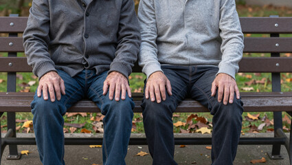 Fototapeta premium Older and younger adults sharing a quiet garden bench
