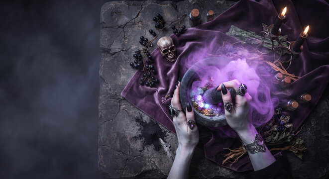 Witch hands grinding magical herbs in a mortar with purple halloween smoke