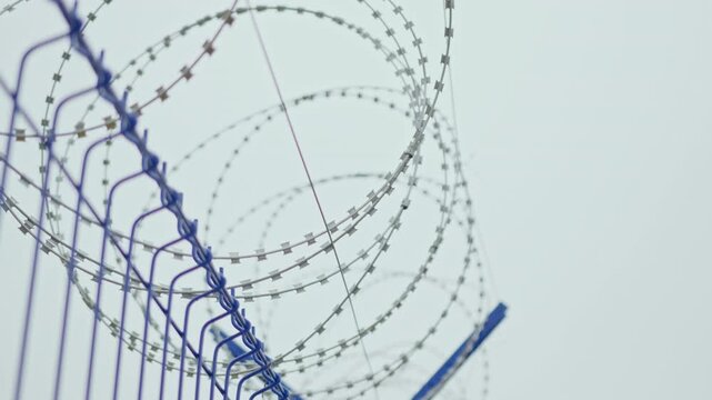 Egoza-style razor-wire barrier has distinctive coiled configuration. Reinforced construction creates physical obstacle around technical site