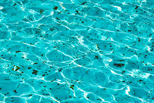 A close-up view of the detailed texture of the water in a pool or fountain, illuminated by the sun's rays	
