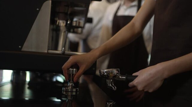 Teenage barista trainee gives OK sign at coffee machine in cafe