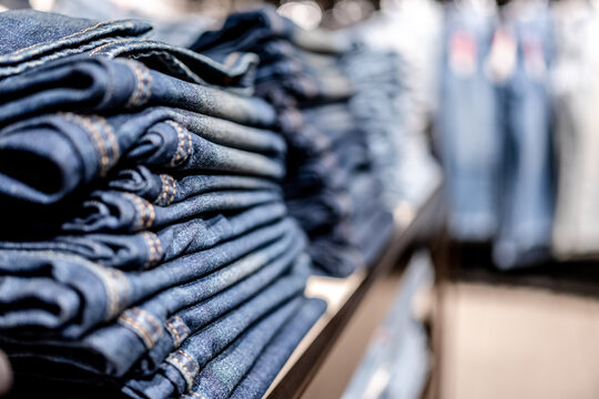 Stacks of folded blue denim jeans in a retail store