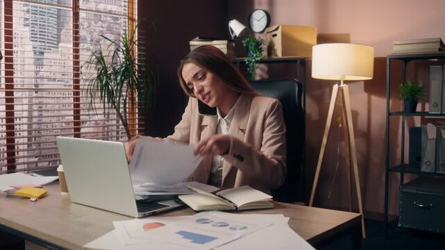 Stress Caucasian business woman throwing away papers documents talking mobile phone drinking coffee at office with laptop multitasking girl female businesswoman chaos mess talk call throw reports