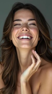 Beautiful laughing woman touching her skin with joy.