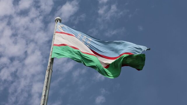 Uzbekistan Flag Waving Against Blue Sky with Moving Clouds