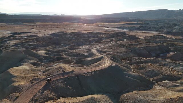 Drone View of ATV Vehicle Moving on Desert Road in Utah USA, Factory Butte Area on Sunny Afternoon