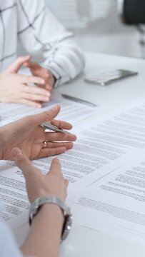 Business people discussing contract terms, outlining agreements, and reviewing legal documents during a corporate meeting, preparing for a significant partnership signing and negotiation