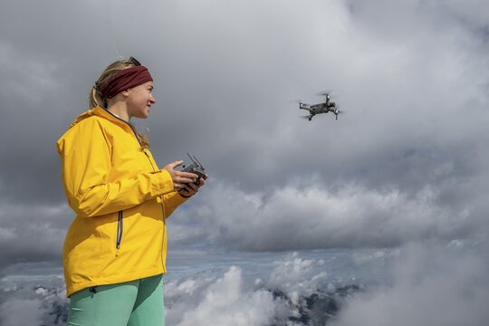 Young woman flying a drone with camera, DJI Mavic Pro, Garmisch Partenkirchen, Bavaria, Germany