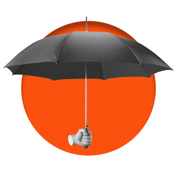 A hand holds a black umbrella against a solid orange circle in the background. The setting is simple with no distractions present. The focus is on the hand and umbrella.