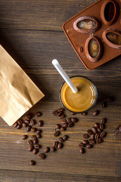 coffee with ice in glass on wooden background top view