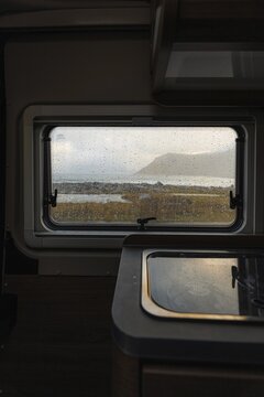 View from rainy campervan kitchen window on Flakstad beach, Flakstad, Lofoten, Norway