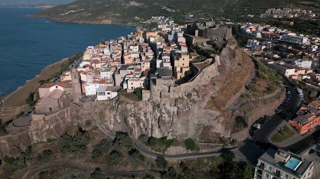 Panoramic aerial view of the Castelsardo, a medieval town in northern Sardinia (Sassari province) on the Gulf of Asinara. It features cascading, colorful houses and a historic fortress.
