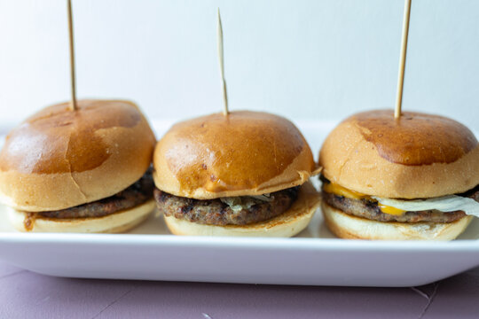 mini burgers or sliders served on a stylish wooden board