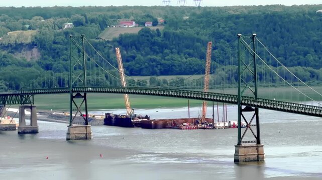 &Icirc;le d'Orl&eacute;ans Bridge spanning across the river with construction cranes below in Quebec, Quebec, Canada.