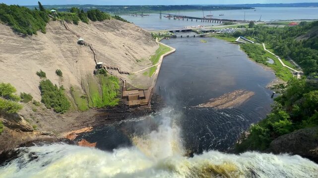 Tourists view Montmorency Falls from wooden stairs in Quebec City, Quebec, Canada.