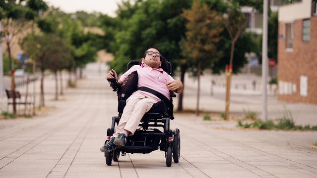 Person with physical disability using an electric wheelchair, navigating a city street. Mobility and independence concept