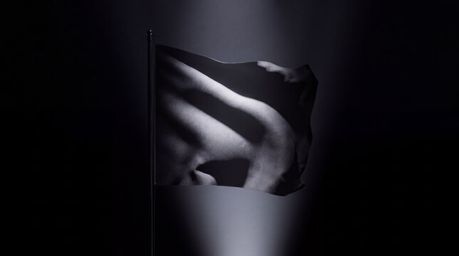 "Black Flag Illuminated by Dramatic Spotlight at Night"