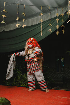 Balinese traditional Rangda dancer in ornate mask and costume performing ritual stage dance performance