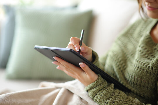 Woman hand handwriting on digital tablet in winter at home