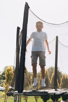 Happy Boy Enjoying Outdoor Trampoline Fun